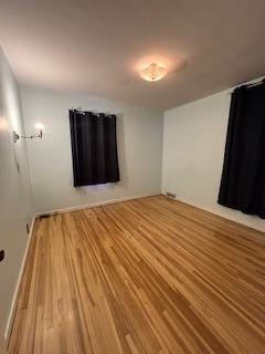 unfurnished bedroom featuring wood finished floors and baseboards