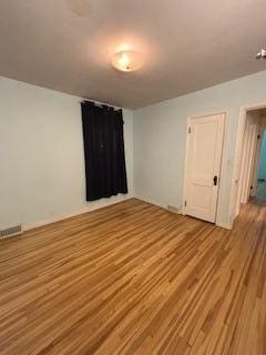 unfurnished room with visible vents and light wood-style flooring