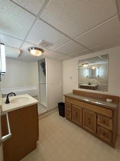 bathroom featuring a sink, a paneled ceiling, and tile patterned floors