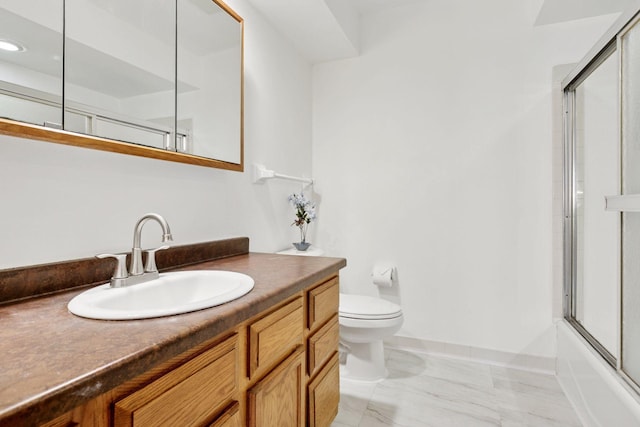 bathroom with baseboards, toilet, enclosed tub / shower combo, marble finish floor, and vanity