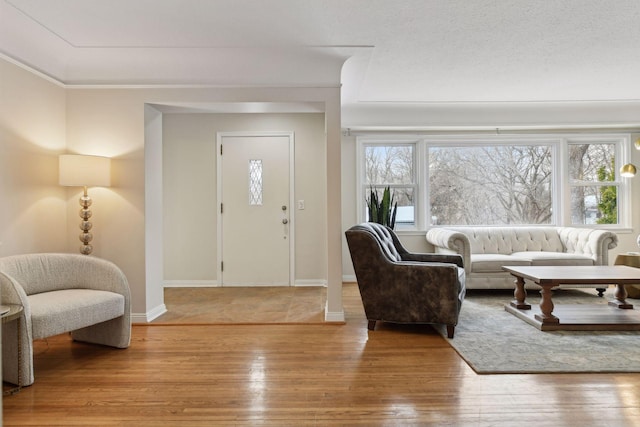 entryway with ornamental molding and wood-type flooring