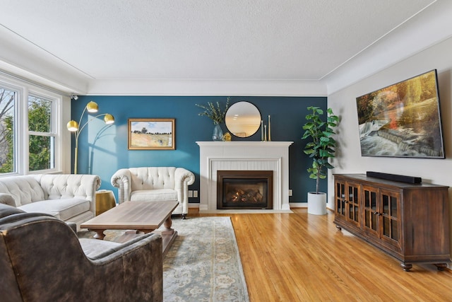 living room featuring a brick fireplace, hardwood / wood-style flooring, and a textured ceiling