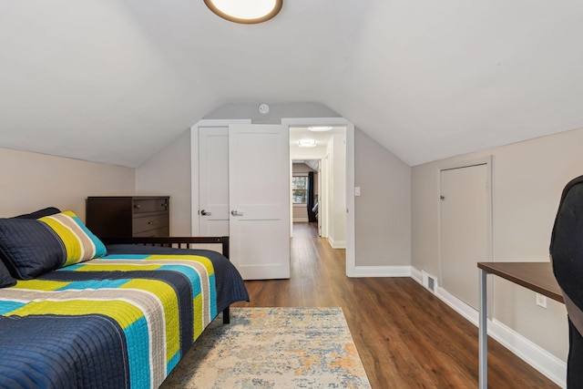 bedroom with dark hardwood / wood-style flooring and vaulted ceiling