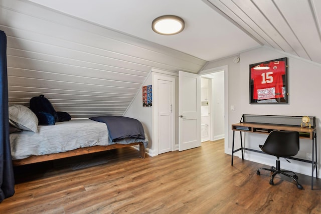 bedroom featuring vaulted ceiling and wood-type flooring