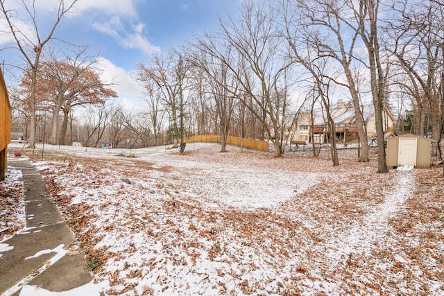 yard covered in snow featuring a storage shed