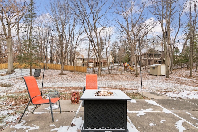 snowy yard featuring a playground and an outdoor fire pit