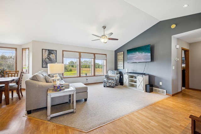 living room featuring visible vents, a ceiling fan, vaulted ceiling, wood finished floors, and baseboards