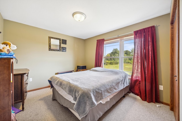 bedroom featuring light colored carpet and baseboards