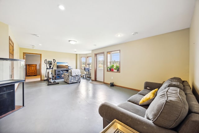 living room with baseboards, concrete flooring, and recessed lighting