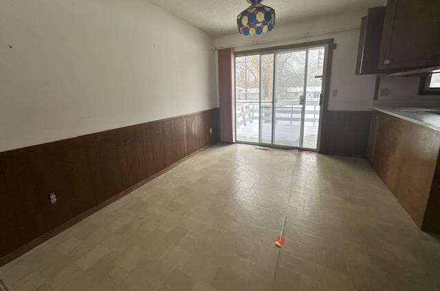 unfurnished dining area with wood walls