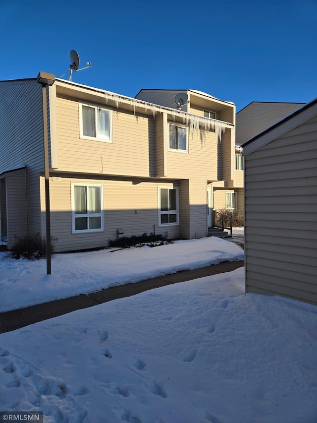 view of snow covered rear of property