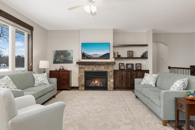 living room with a fireplace and ceiling fan