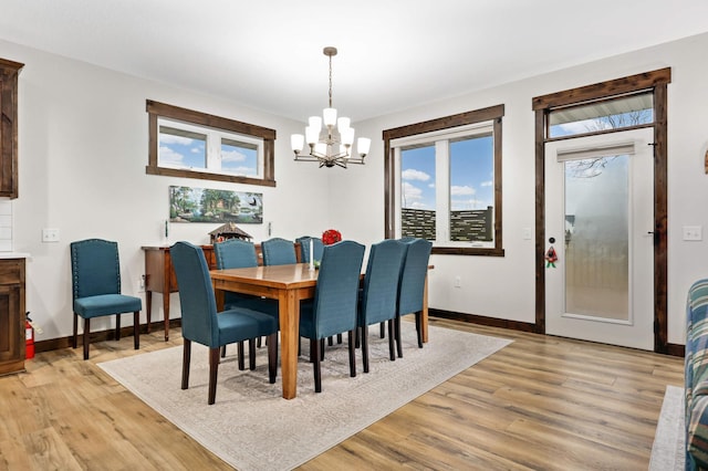 dining space featuring light wood-type flooring and a chandelier