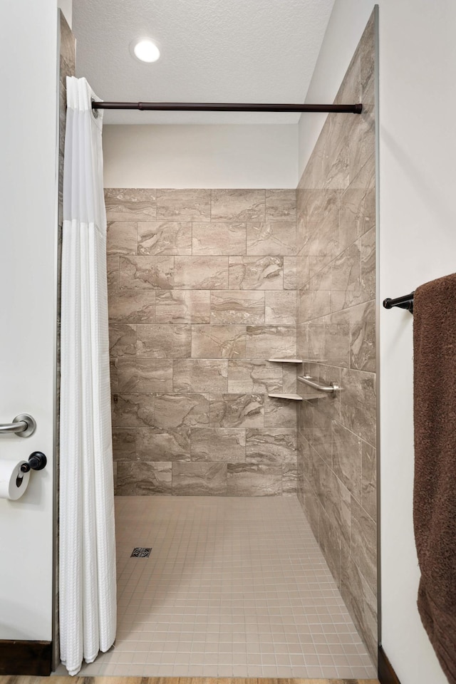 bathroom featuring a textured ceiling and a shower with curtain