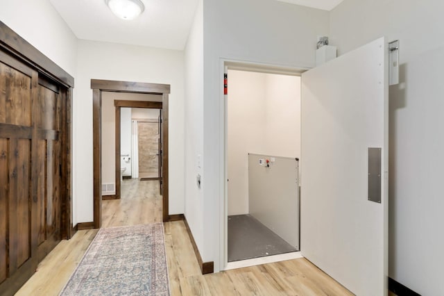 hallway with light hardwood / wood-style floors