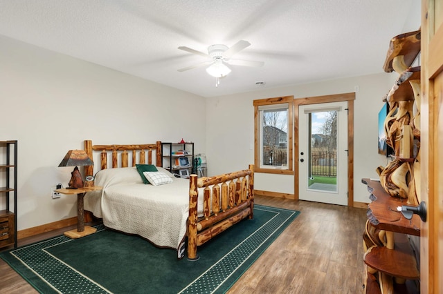 bedroom featuring hardwood / wood-style floors, ceiling fan, access to exterior, and a textured ceiling