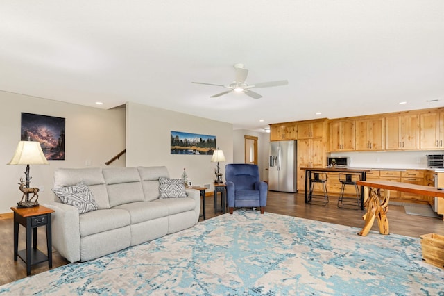 living room featuring ceiling fan and dark wood-type flooring