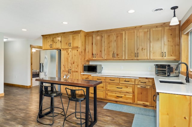 kitchen with sink, appliances with stainless steel finishes, dark hardwood / wood-style floors, and decorative light fixtures