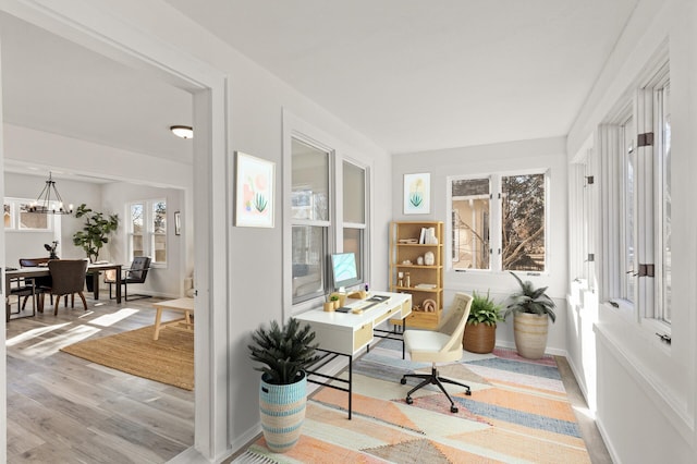 office featuring baseboards, an inviting chandelier, and wood finished floors