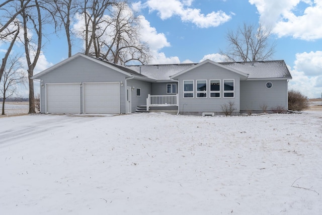 snow covered rear of property featuring a garage