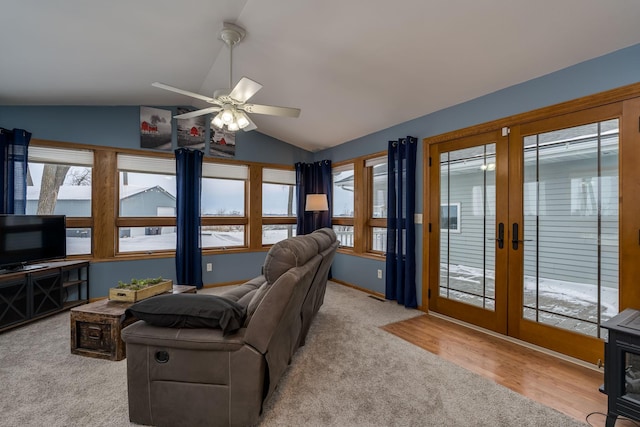 living room featuring light wood-type flooring, lofted ceiling, ceiling fan, and french doors