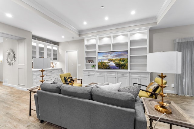 living room with a raised ceiling, light hardwood / wood-style flooring, and crown molding