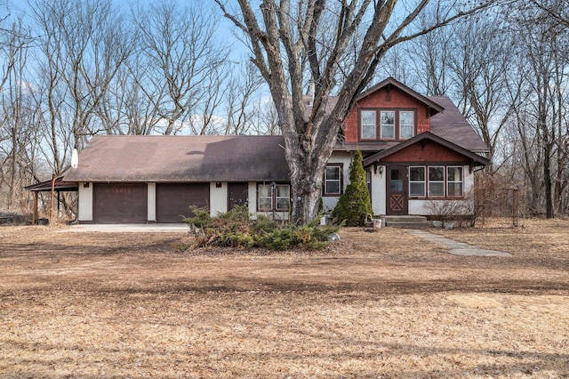 view of front of house featuring an attached garage and dirt driveway