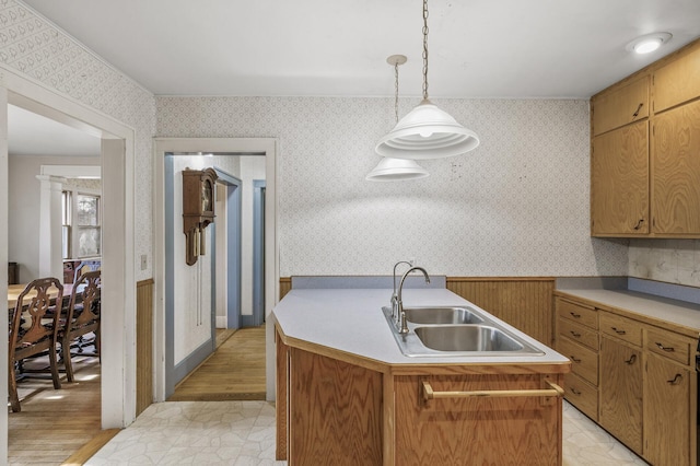 kitchen with light countertops, a sink, and wallpapered walls