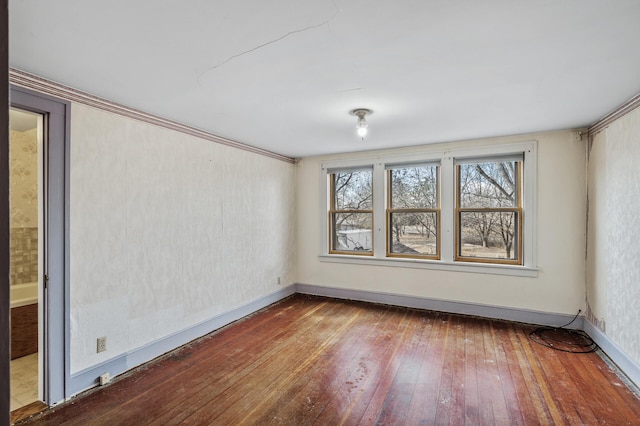 empty room featuring baseboards and hardwood / wood-style floors