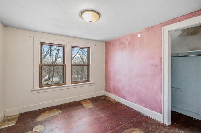 unfurnished bedroom with wood-type flooring and baseboards