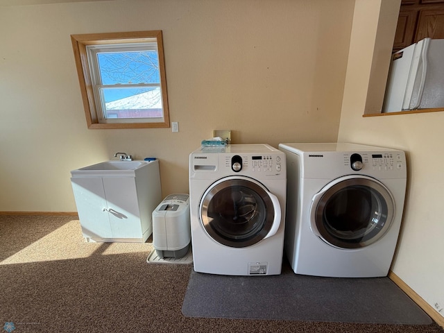 laundry area with dark carpet, cabinets, washer and clothes dryer, and sink