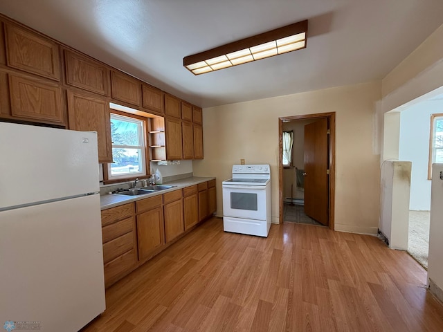 kitchen with sink, white appliances, a baseboard radiator, and light hardwood / wood-style flooring