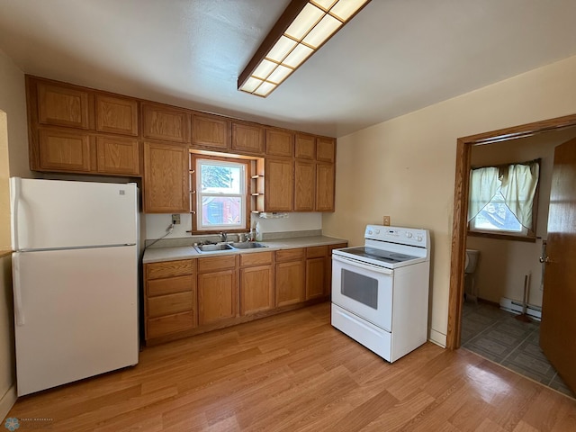 kitchen with sink, white appliances, a baseboard radiator, and light wood-type flooring