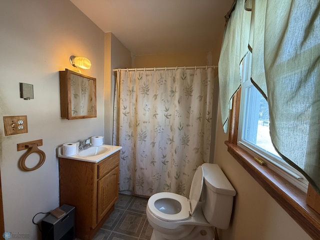 bathroom with toilet, vanity, and a shower with curtain