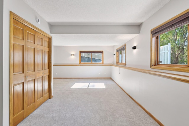 spare room with light carpet and a textured ceiling