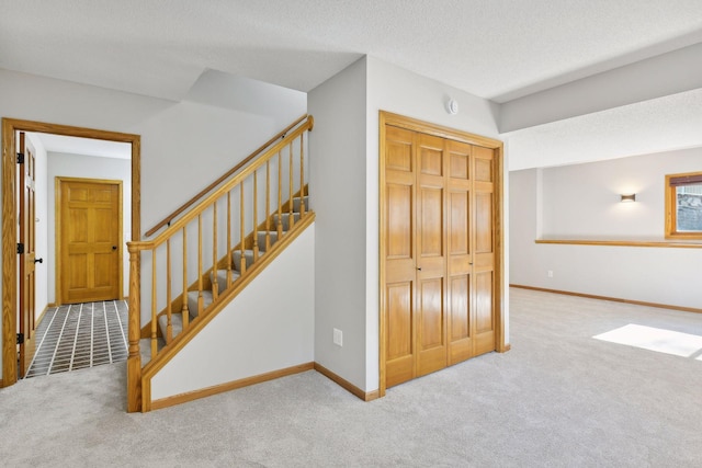 stairs with carpet flooring and a textured ceiling