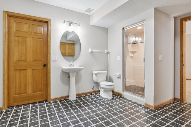 bathroom featuring sink, an enclosed shower, and toilet