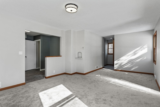 spare room with a textured ceiling and light colored carpet