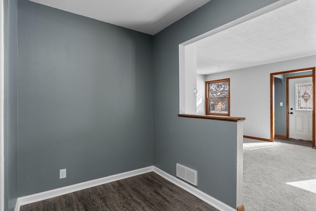 unfurnished room featuring hardwood / wood-style flooring and a textured ceiling