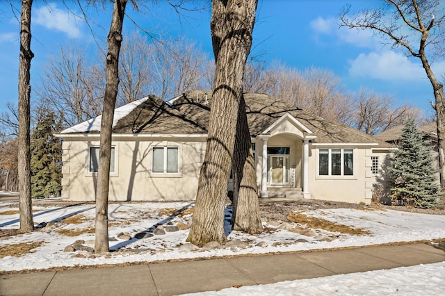 view of front of home with roof with shingles and stucco siding