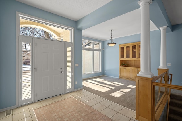 entryway with visible vents, baseboards, light carpet, light tile patterned floors, and ornate columns