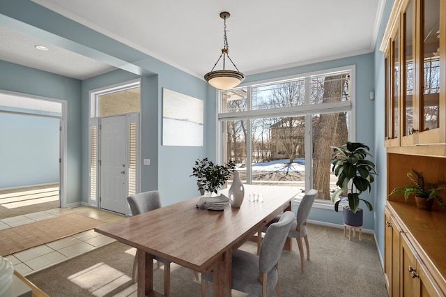 dining area with light tile patterned floors, baseboards, and ornamental molding