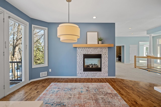 living area featuring visible vents, baseboards, recessed lighting, a tile fireplace, and wood finished floors