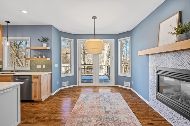 interior space featuring dishwasher, open shelves, visible vents, and a sink