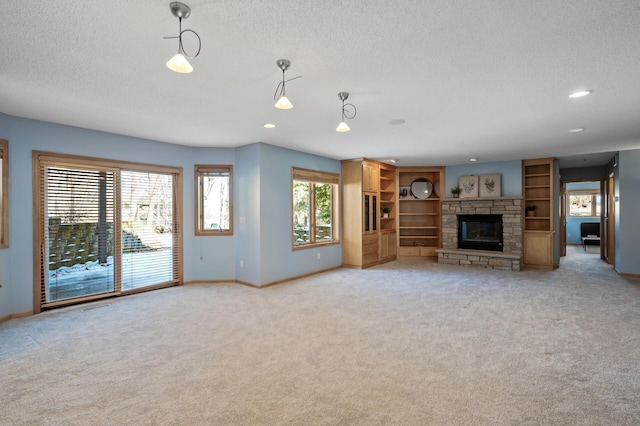 unfurnished living room with a textured ceiling, recessed lighting, a stone fireplace, baseboards, and light colored carpet