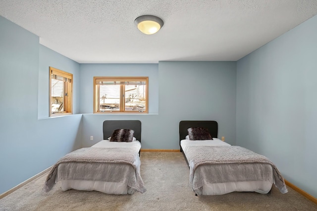 carpeted bedroom featuring a textured ceiling and baseboards