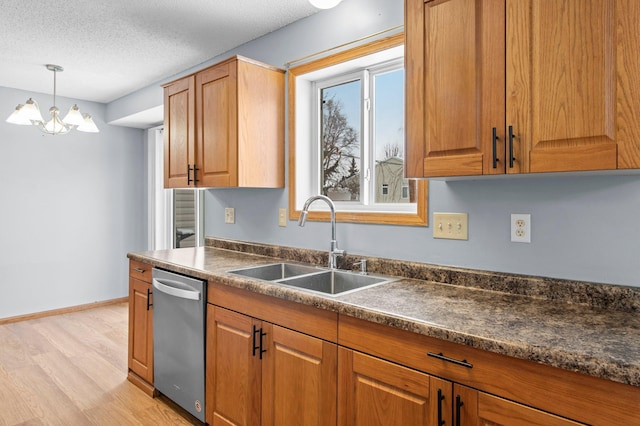 kitchen featuring sink, a textured ceiling, light hardwood / wood-style floors, stainless steel dishwasher, and hanging light fixtures