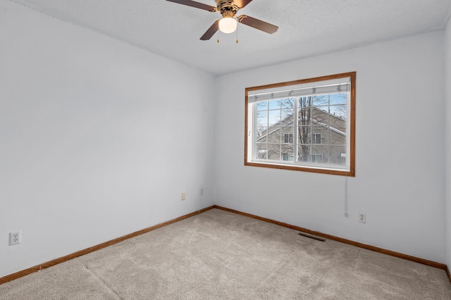 spare room with ceiling fan, carpet flooring, and a textured ceiling