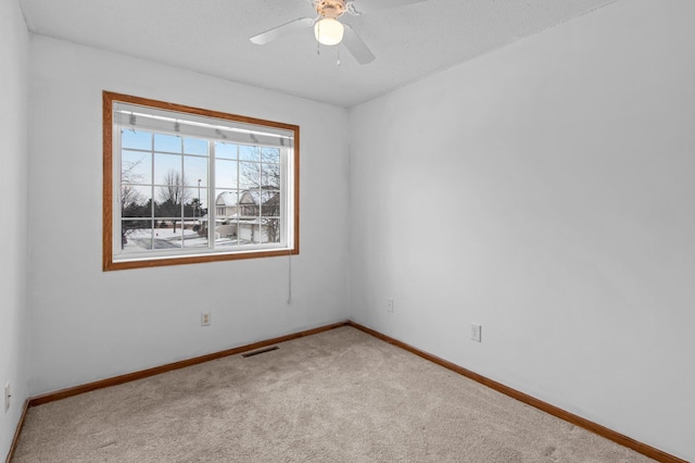 unfurnished room featuring light carpet and ceiling fan