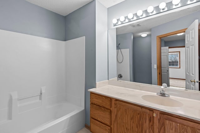 bathroom featuring vanity, shower / tub combination, and a textured ceiling